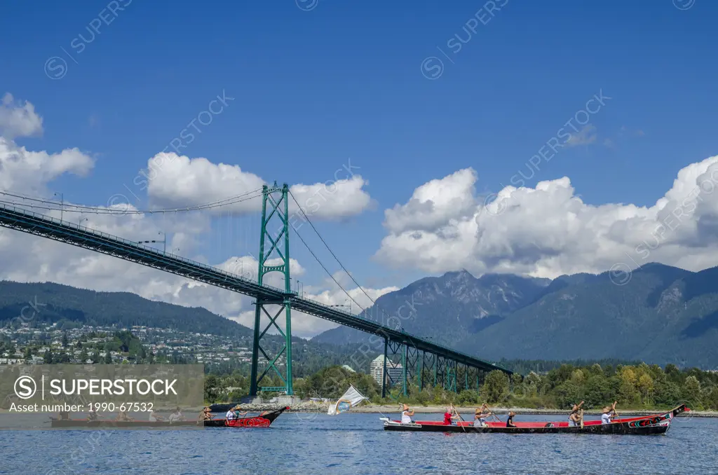 First Nations canoe passes under Lions Gate Bridge. Many People, One Canoe. Salish First Nations, Gathering of Canoes to Protect the Salish Sea, North...