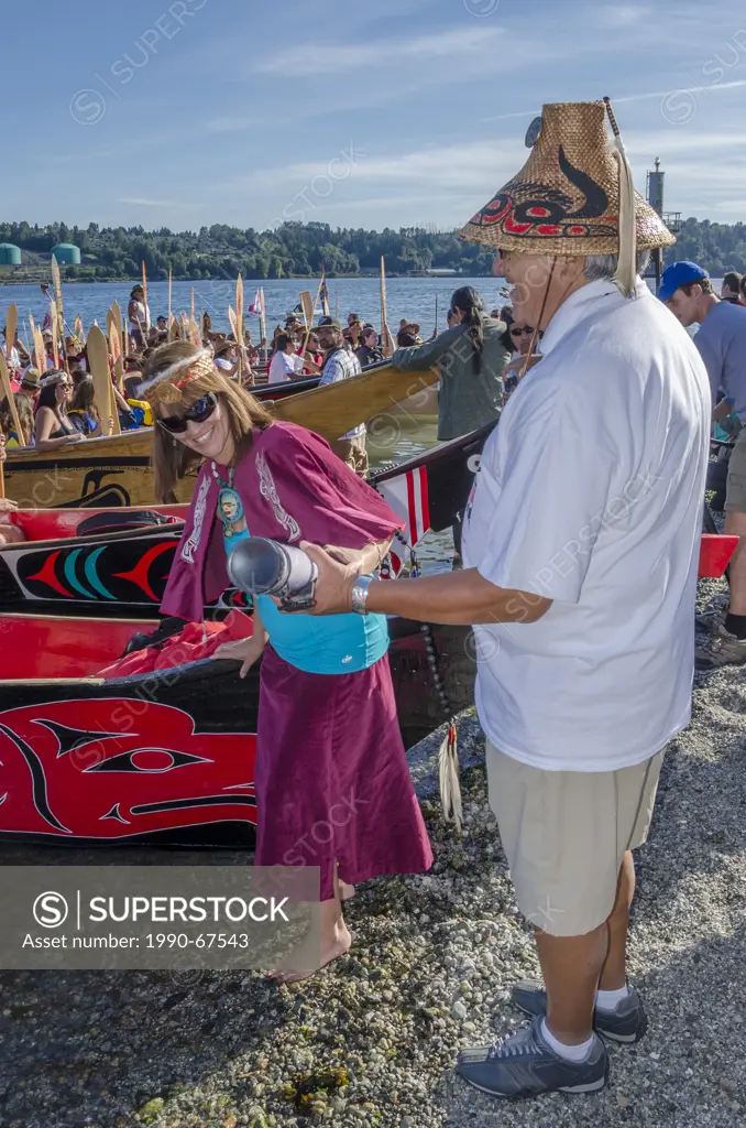 Chief Gibby Jacob of Squamish Nation receives declaration from writer, un_confirmed Briony Penn. on the beach at Whey_ah_Wichen Cates Park, Many Peopl...