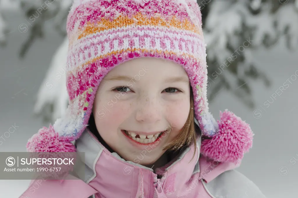 Smiling young girl dressed for and enjoying winter in Canada, Sherwood Park, Alberta, Canada