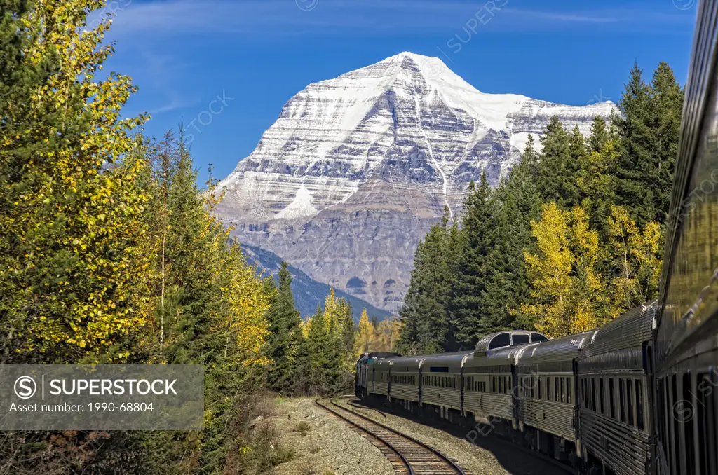 Passenger train with Mount Robson, the highest peak in the Canadian Rockies at 12,972 feet. British Columbia, Canada.