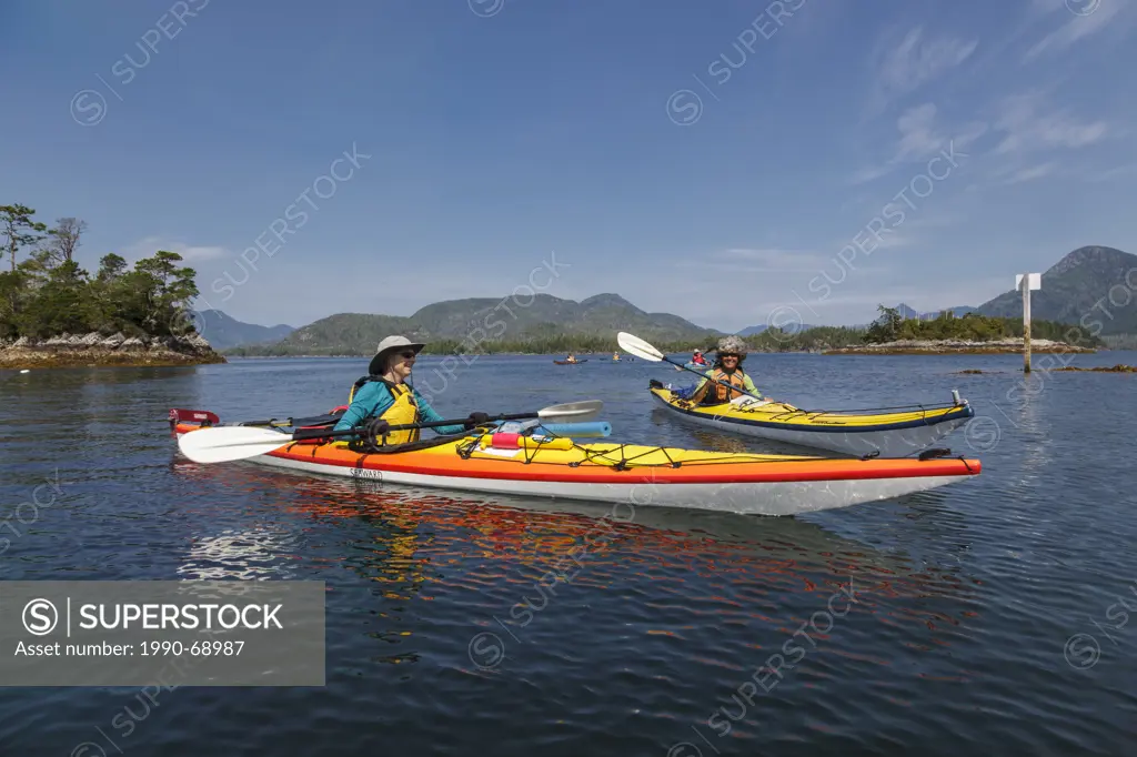 Kayakers await pickup by the supply ship the Uchuck 111 at Flynn´s Cove, Nootka Island, British Columbia, Canada. Model Released