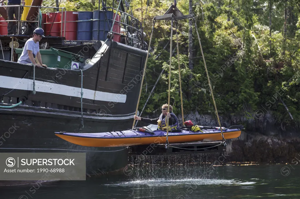 A kayaker is lifted onto the supply ship the Uchuck 111 at Flynn´s Cove, Nootka Island, British Columbia, Canada.