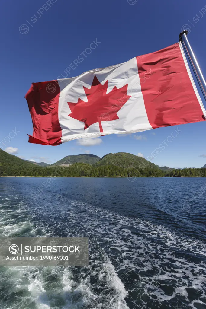 The Canadian Flag flies from the stern of the Uchuck 111 as it traverses Esperanza Inlet, British Columbia, Canada.
