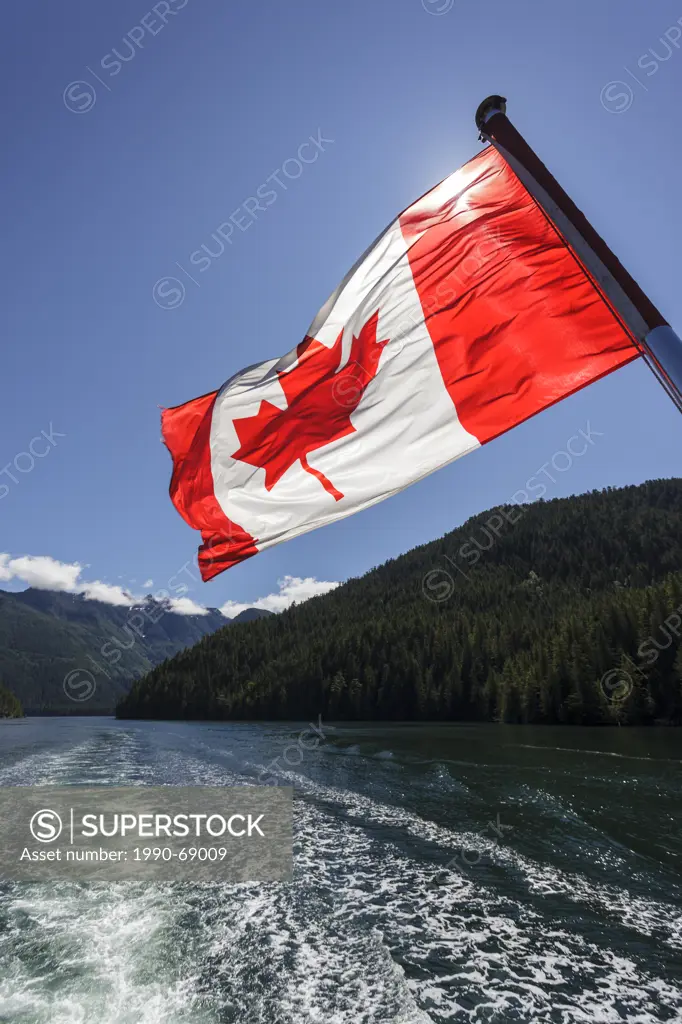 The Canadian Flag flies from the stern of the Uchuck 111 as it traverses Esperanza Inlet, British Columbia, Canada.