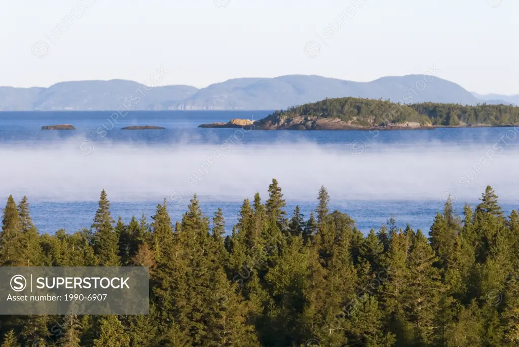 Mist rising from Lake Superior on a cool morning as seen from the boreal forests of Pukaskwa National Park  Heron Bay, Ontario, Canada