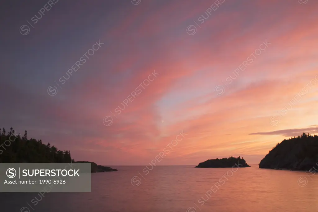 Sunset and crescent moon over Lake Superior in Pukaskwa National Park, Heron Bay, Ontario, Canada