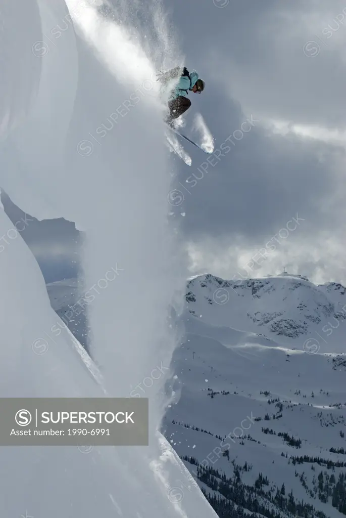 A daring skier takes the plunge off a cornice in the backcountry of Blackcomb Mountain, British Columbia, Canada