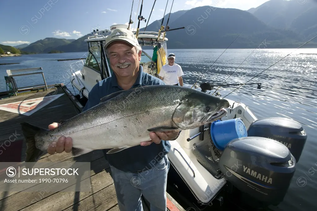 Sportfishermen holding Coho Salmon, Port Alice, Northern Vancouver Island, British Columbia, Canada