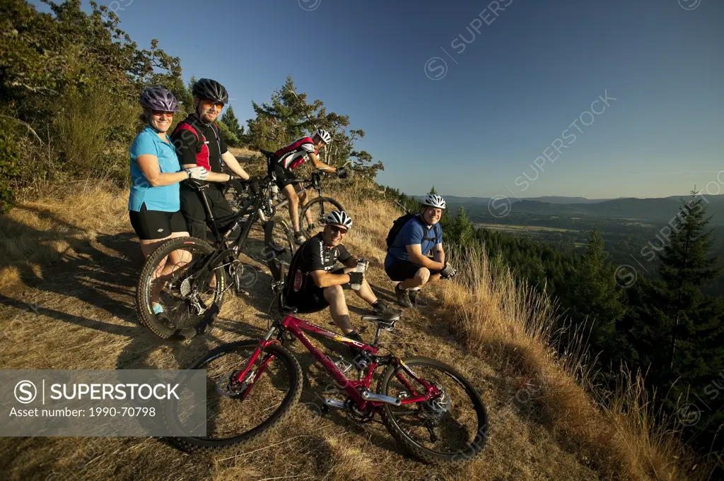 A group of friends stop for a rest on Mt. Tzoulalem, Duncan, Central Vancouver Island, British Columbia, Canada