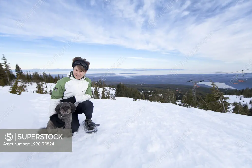 A woman and her small dog snowshoeing on Forbidden Plateau, Comox Valley, Vancouver Island, British Columbia, Canada