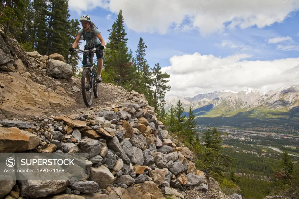 A female mountain biker riding the Highline trail in Canmore, AB