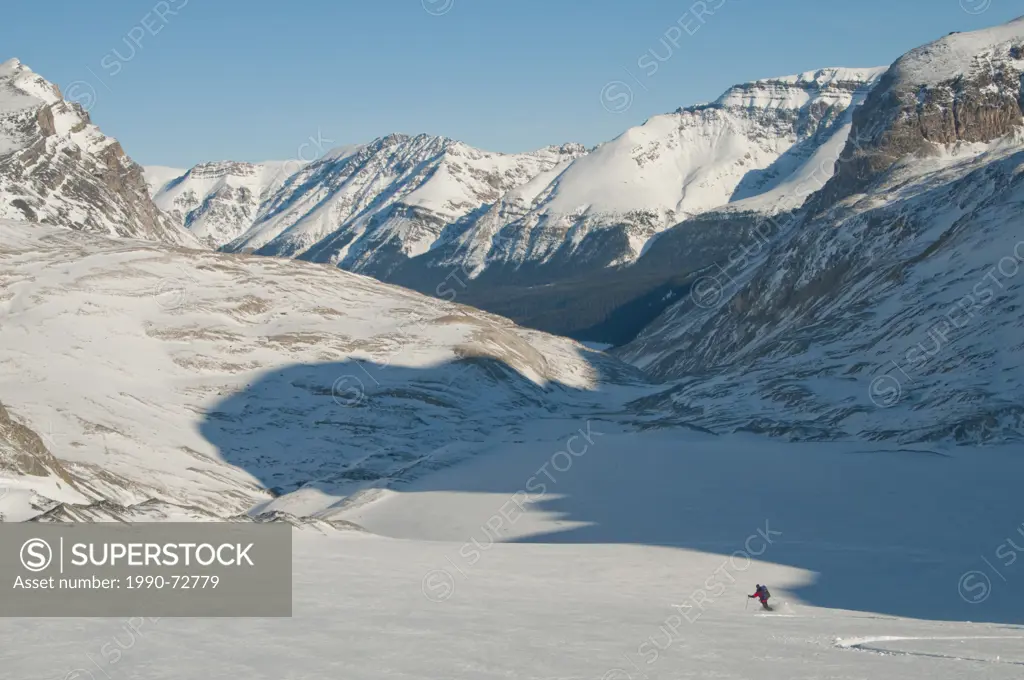 Skier descending glacier on Wapta Icefield toward Peyto Lake, Banff National Park, Alberta, Canada