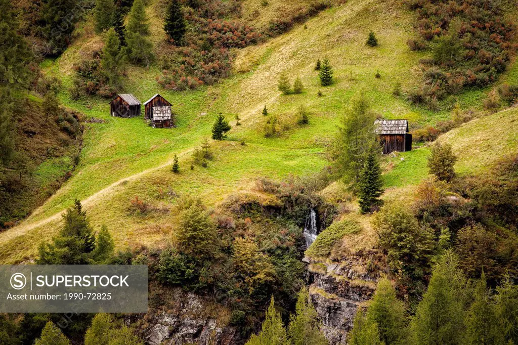 Small wooden huts/sheds on the slopes of the Dolomite Mountains in northern Italy.