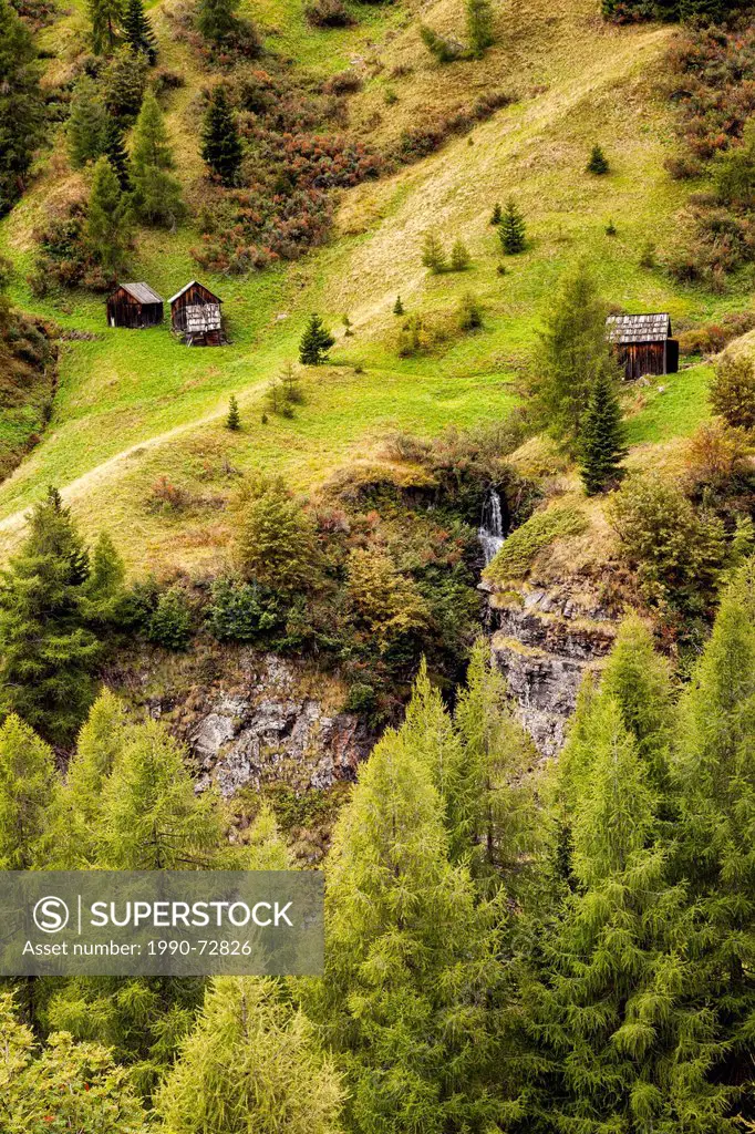 Small wooden huts/sheds on the slopes of the Dolomite Mountains in northern Italy.