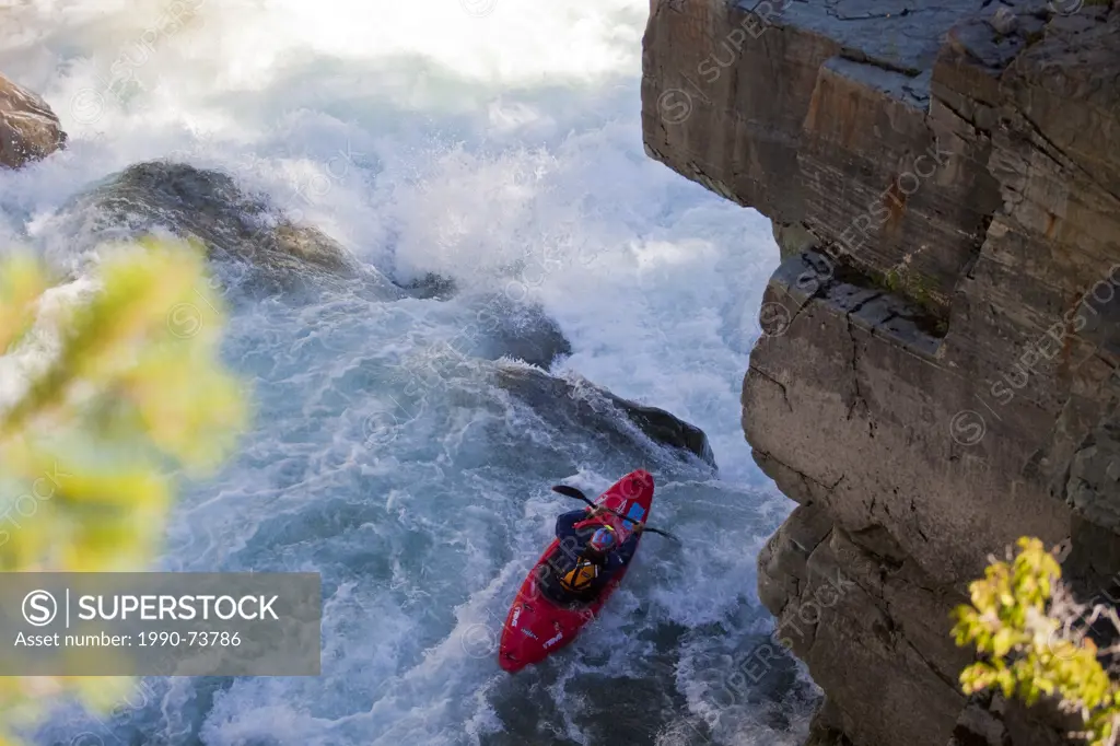 A male kayaker runs the challenging section of the Upper Elk River, Fernie, BC