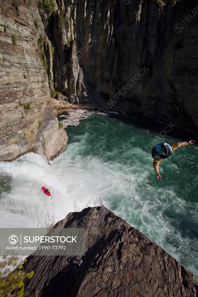 A male kayaker runs leap of faith, a 30 foot waterfall while a cliff jumper jumps from 70ft on the Upper Elk River, Fernie, BC