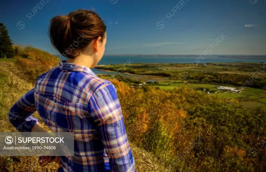 Woman looking out towards Annapolis Valley in the fall, Nova Scotia.