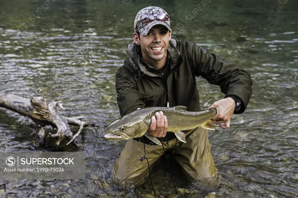 Fihserman with bull trout (Salvelinus confluentus), Mitchell River, Cariboo Mountains, British Columbia, Canada