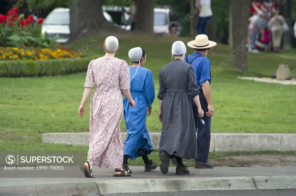 Mennonite girls with father walking on a street in Niagara Falls, Ontario, Canada