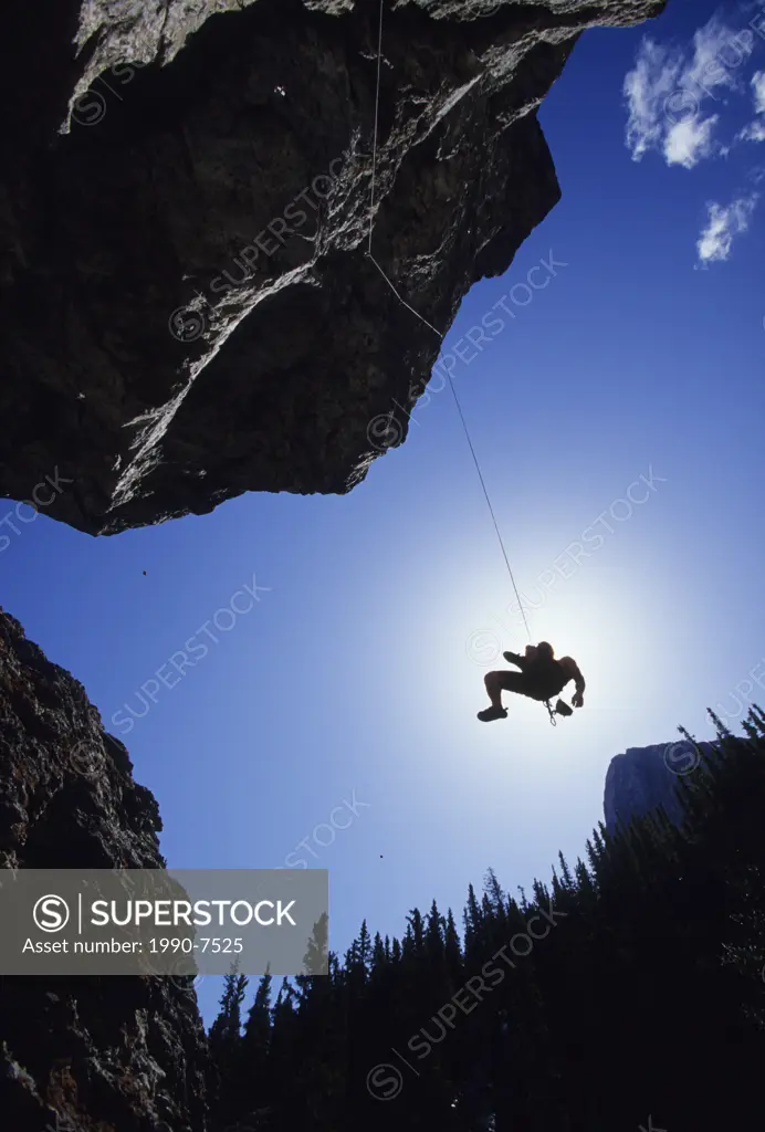 A young man being lowered after he leads, Grassi Lakes, Canmore, Alberta, Canada