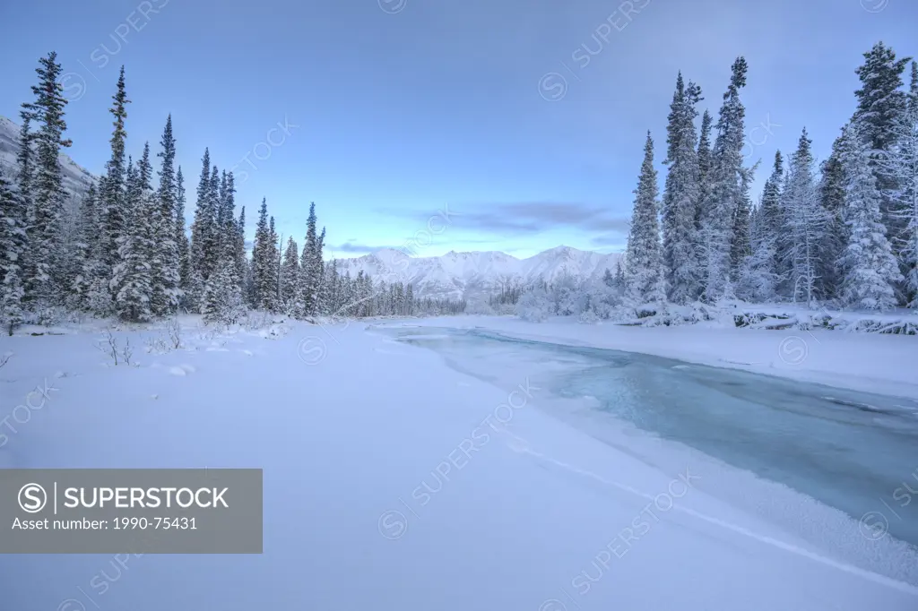 The blues of winter in the Wheaton Valley just outside of Whitehorse, Yukon. The Wheaton River is slowly freezing as the deep cold of winter settles i...