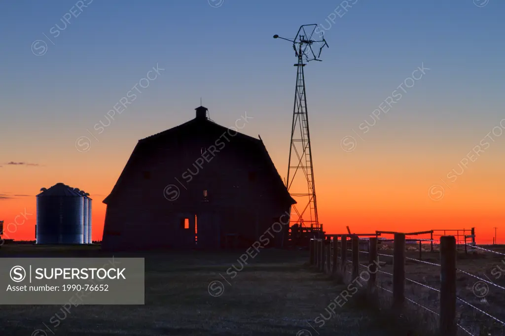 Sunrise on old barn yard with windmill. Carsland, Alberta, Canaada