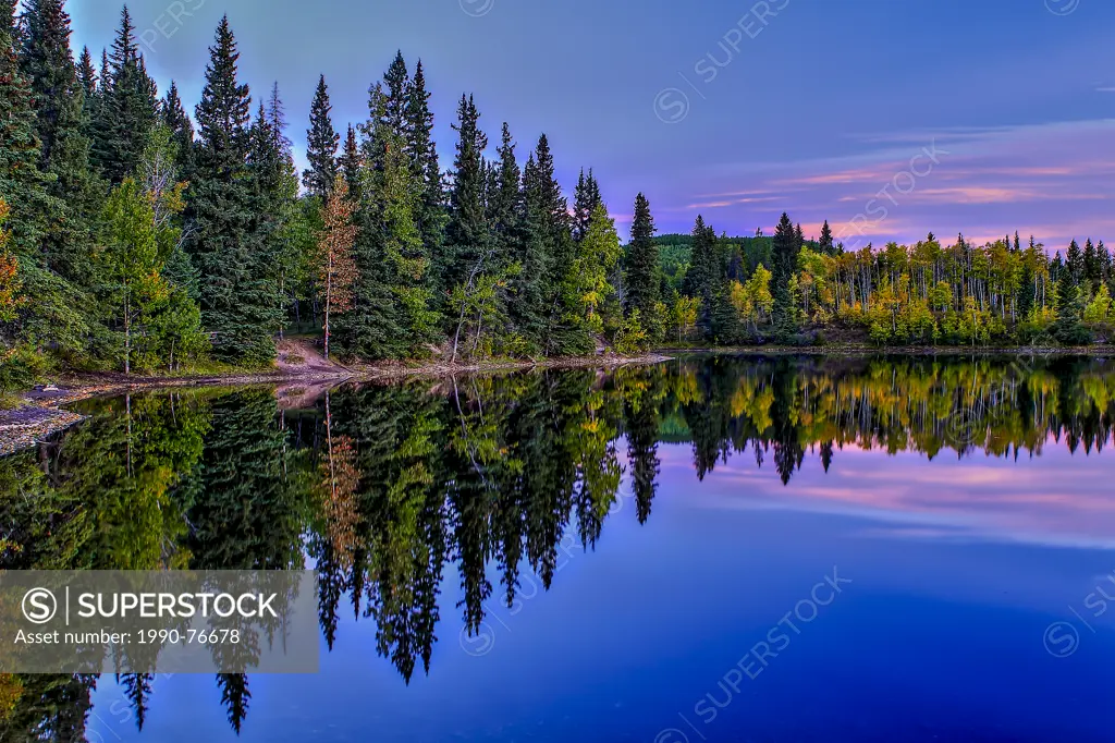 Sibbald Lake as seen in the fall at sunrise. Nice reflections of the sky and trees in the water.