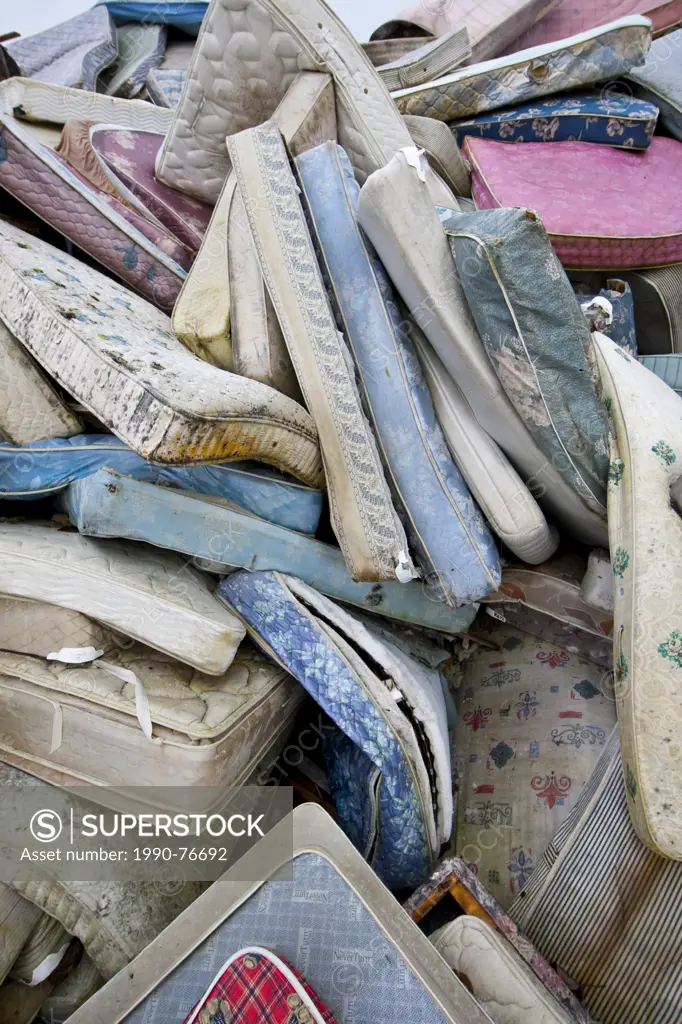 Former mattresses lie piled up ready for dispersal at a landfill near Cumberland in the Comox Valley. Cumberland, The Comox Valley, Vancouver Island, ...