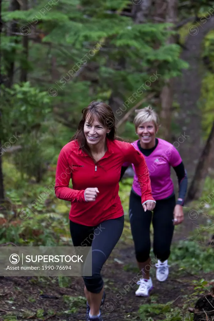 Two friends run along trails near the Cape Lazo marsh in Comox. Comox, The Comox Valley, Vancouver Island, British Columbia, Canada.