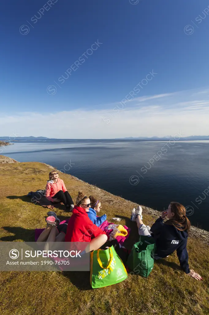 A family outing turns to laughter while having lunch along the cliffs of Helliwell on Hornby Island. Hornby Island, Northern Gulf Island's, British Co...