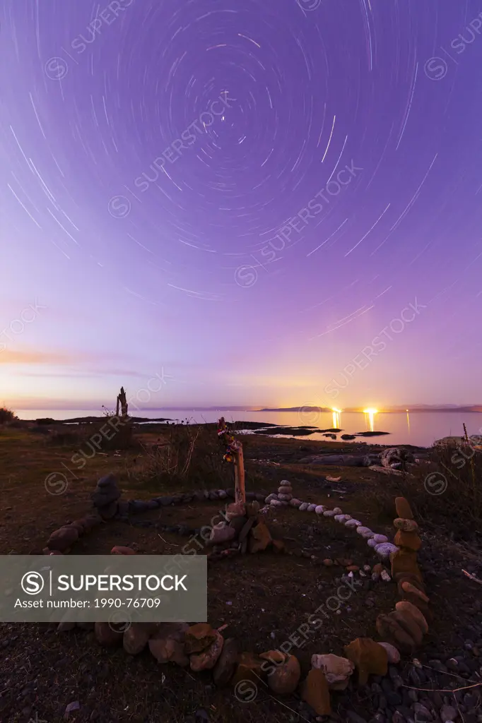 Ambient light from star trails outlines a medicine wheel or sacred hoop on Hornby Island. Hornby Island, Northern Gulf Islands, British Columbia, Cana...