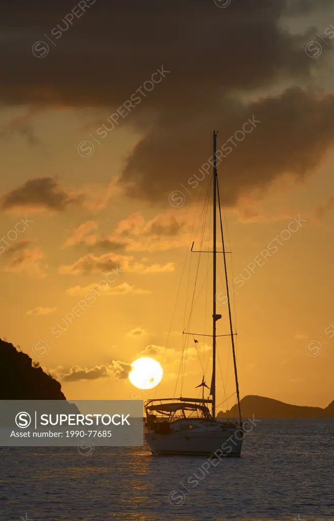 Sailboat at anchor in front of the sun, Norman Island, British Virgin Islands
