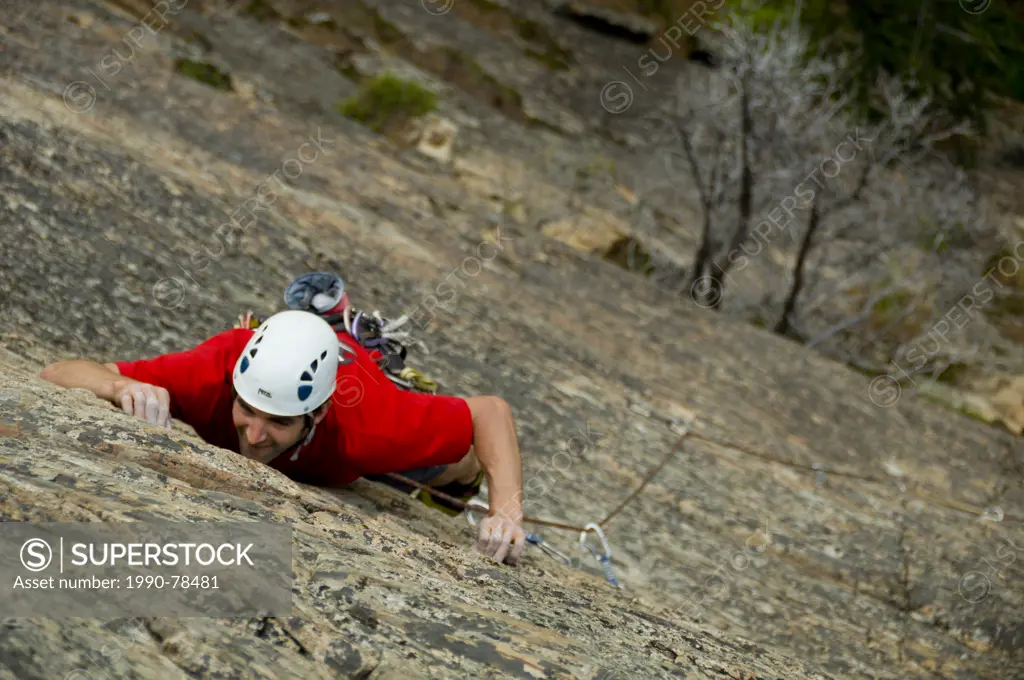 A young male climber makes his way up a steep face at Skaha Provincial Park, Penticton, British Columbia