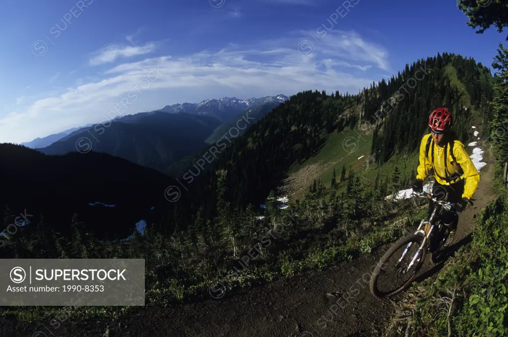 A young woman mountain biking on the spectacular Idaho Peak, New Denver, British Columbia, Canada