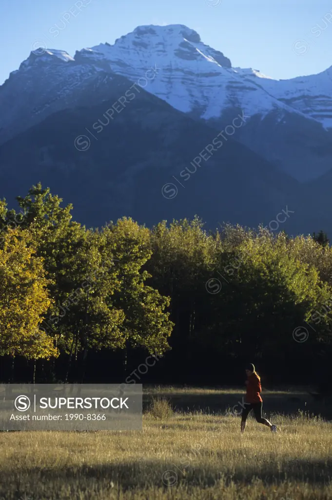 A young woman enjoying a fall trail run in Banff National Park, Rocky Mountains, Alberta, Canada
