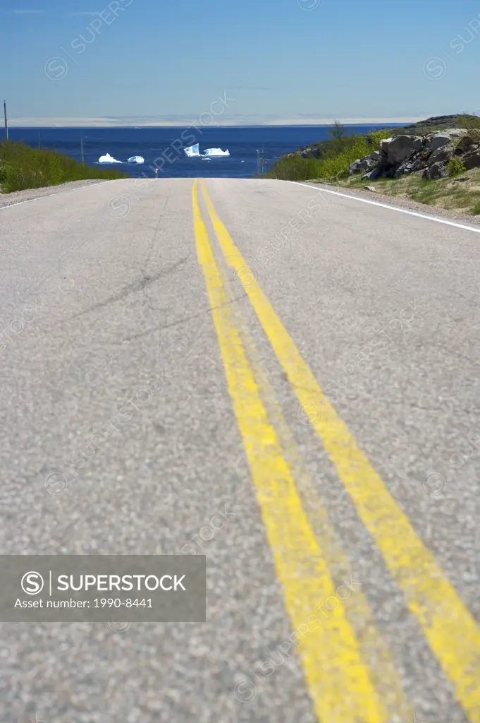 Highway 510, also known as the Labrador Coastal Drive, leading towards the town of Pinware along the coast with icebergs near the shore of Pinware Riv...