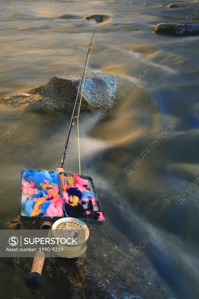 Flyrod and flybox on rocks in river, Bulkley river, Smithers, British Columbia, Canada.