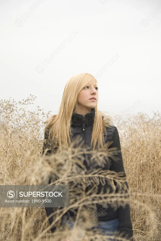 Caucasian female portrait in field of brush, Alberta, Canada.