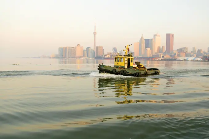 Tugboat in fornt of Toronto city skline, Toronto, Ontario, Canada