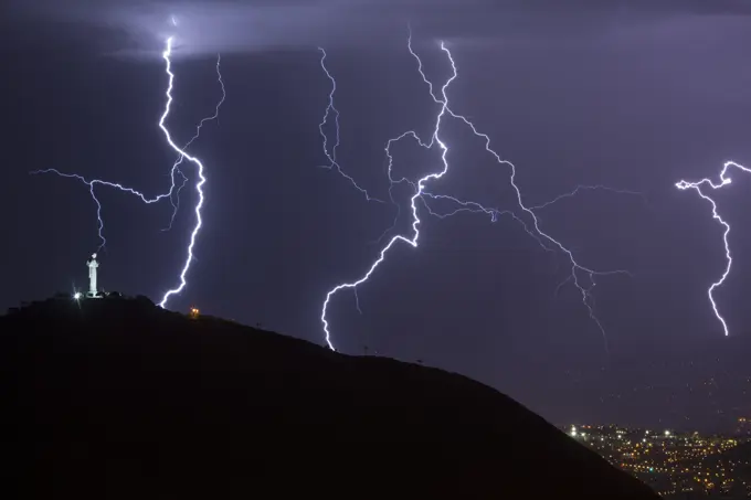 Lightning during a thunderstorm over the city of Cochabamba, Bolivia. El Cristo is in the foreground.