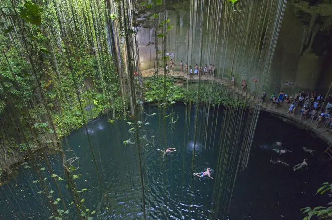 Tourists swimming in Ikil cenote on Yukatan peninsula in Mexico