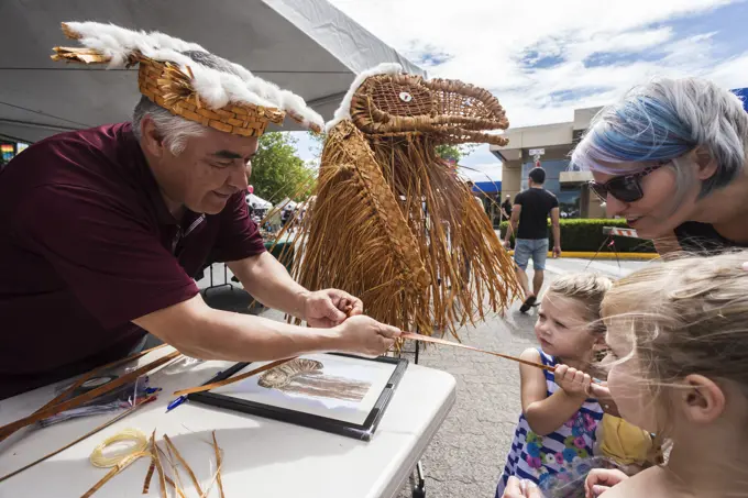 A first nation weaver works with cedar strips and a little help from a young onlooker during Canada Day celebrations held in Campbell River, Campbell ...