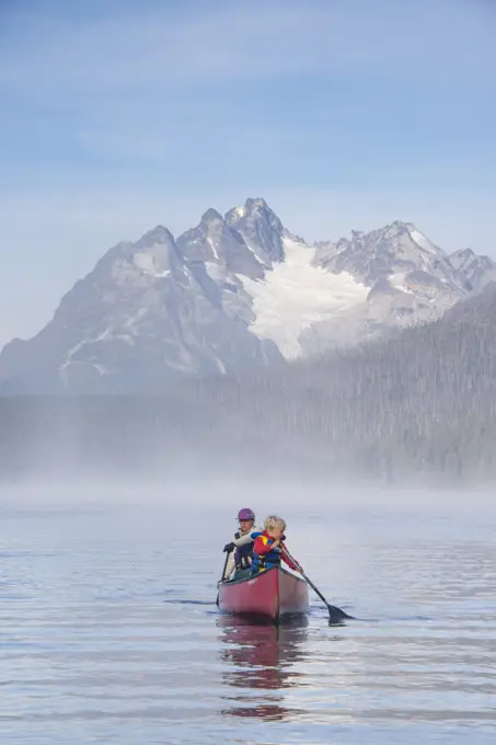 A woman and her son paddling on Widgeon Lake, Turner Lakes chain, Tweedsmuir, British Columbia