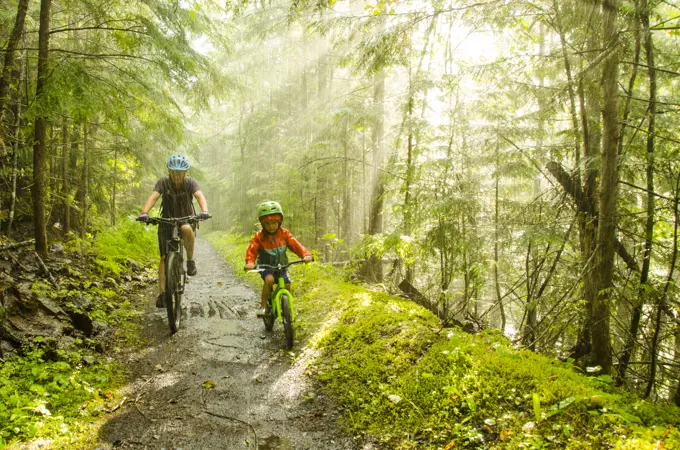 A young boy and his mom getting caught in the rain on the beautiful Galena trail, New Denver, British Columbia