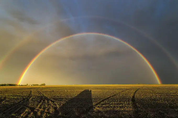 End of storm double rainbow over field in southern Manitoba Canada
