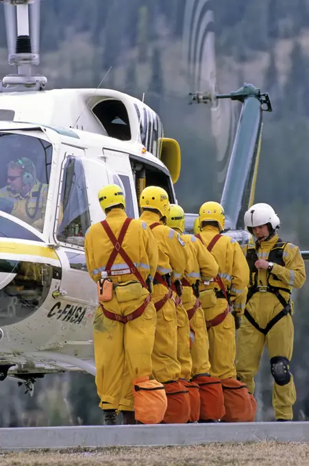 A forest firefighting crew preparing to board a helicopter for transportation to a forest fire.