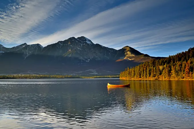 A landscape image of a cedar strip canoe moored on Pyramid Lake in Jasper National Park Alberta Canada.