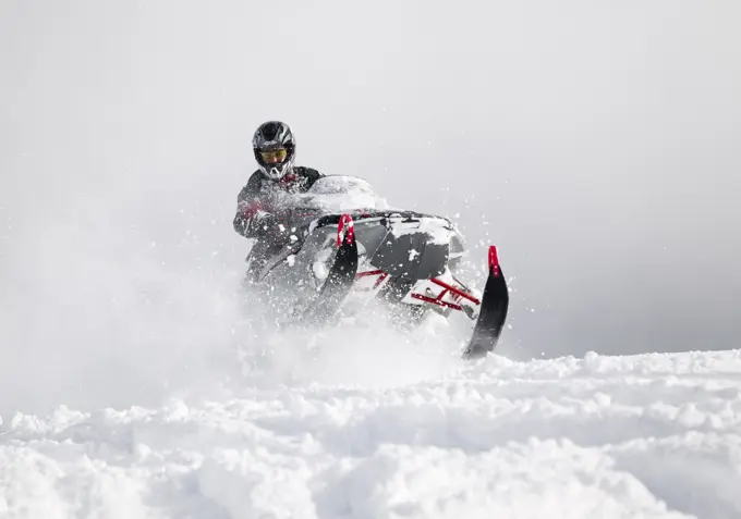 Fresh and deep powder greets this snowmobiler punching through snowdrifts in the mountains north of Campbell River. Campbell RIver, Vancouver Island, ...