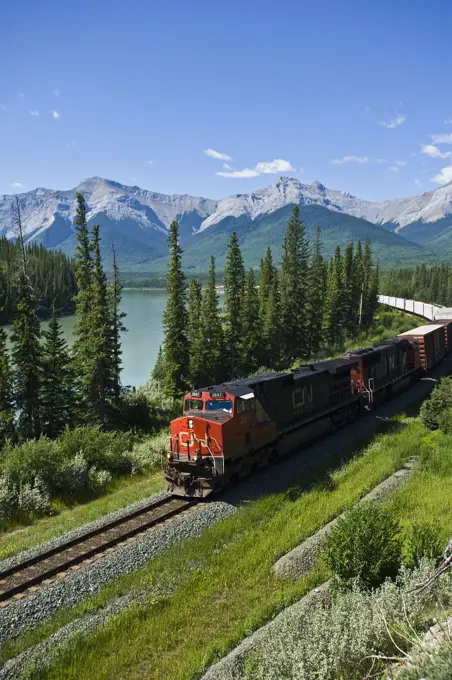 Freight train traveling on a rail line beside Jasper Lake in Jasper National Park, jasper, Alberta, Canada