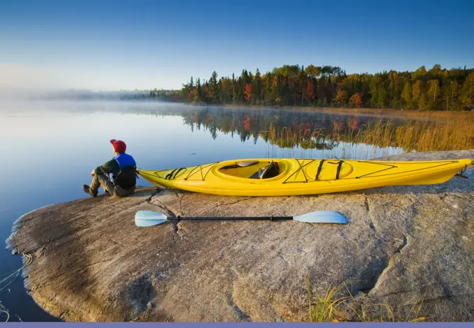 Man with kayak,Bunny Lake, near Sioux Narrows, Northwestern Ontario, Canada